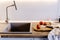 wooden board with knife, tomatoes, towel, spices on modern kitchen countertop near granite sink and steel faucet. cooking food.