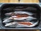 On a wooden board in a metal container of carcasses of fresh caviar of river fish pike. Winter fishing