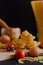 Wooden board with pasta, cherry tomatoes, two eggs and a grinding bowl, sprinkled with spices