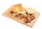 Wooden board with piece of apple pie and cinnamon on white background