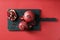 Wooden board with ripe pomegranates on color background