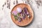 Wooden board with sea salt, bottle of lavender essential oil and cream on light background