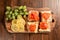 Wooden board with smoked salmon on a cheese and white bread with green grapes and slices of lemon. Top down view, Seafood product