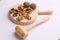 Wooden board with  splashed raw walnuts with hammer on white background