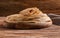 Wooden board with stack of tasty thin pancakes on table