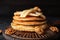 Wooden board with tasty pancakes, sliced banana and walnuts on table, closeup