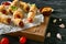 Wooden board with tasty sausage rolls and sauces on wooden table