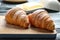 Wooden board with tasty on table, closeup. French pastry