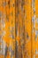 Wooden boards covered with peeling orange paint