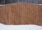 wooden boards pine a fence are covered with wood stain white snow a snowdrift texture a background