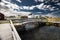 Wooden boardwalk and bridge over a canal with distant East coast beach homes on Bonavista Newfoundland Canada