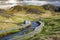 Wooden boardwalk and changing room by geothermal bath stream in Hveragerdi