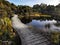 Wooden boardwalk at the edge of the lake Wilkie in the Catlins Coastal area of the South Island of New Zealand