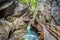 Wooden boardwalk leads through a tight canyon over whitewater, S