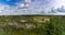 Wooden boardwalk nature trail leading through a peat bog landscape with sparse trees