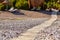 Wooden boardwalk on a tropical beach pebble.