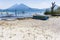 Wooden boat on beach & volcanoes behind, Lake Atitlan, Guatemala