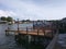 Wooden boat dock, boats on ocean on cloudy day