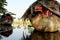 Wooden boat with dried leaves roof, eyes looking straight mooring at river reflect on water, Ho Chi Minh city, Vietnam