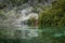 Wooden boat in green wild rainforest lagoon