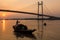 Wooden boat on river Hooghly at sunset near Vidyasagar bridge.