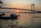 Wooden boat on river Hooghly at sunset with the Vidyasagar bridge at the backdrop