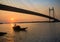 Wooden boat on river Hooghly at sunset with Vidyasagar bridge at the backdrop (silhouette)Kolkata, India.