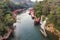 Wooden boat sailing river kwai with waterfall in tropical rainforest