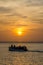 Wooden boat with unidentifiable people and beautiful sunset over sea, Bubaque, Bijagos islands, Guinea Bissau, Africa