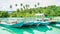 Wooden boats docked at the port. beautiful view of beach with clear blue water and coconut tree,
