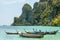 Wooden boats are in the lagoon in front of the rocks