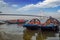 Wooden boats lined up on Hooghly river bank with Vidyasagar bridge Setu at the backdrop