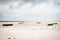 Wooden boats on low tide, toned. Zanzibar beach with old nautical vessel. African seascape with cloudy sky. Empty coast of ocean.