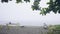 Wooden boats on sandy beach while rain and storm in sea. Rain falling on beach and fishing boat on shore on background