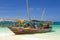 Wooden boats with tourists near sand shore. Zanzibar