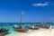 Wooden boats with tourists near sand shore. Zanzibar