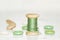 Wooden bobbin with green threads and buttons