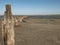 Wooden bollards in the sand against the estuary and blue sky. kuyalnitsky estuary