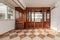 A wooden bookcase with a mirror interior inside the cabinets with glass shelves and stoneware floors in two colors