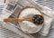 Wooden bowl of black chickpea flour and spoon of beans top view