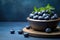 A wooden bowl brimming with fresh, juicy blueberries, sitting prominently on a table, Fresh blueberries in a wooden bowl on a blue