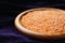 Wooden bowl containing red lentils, dark background