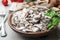 Wooden bowl with delicious cooked mushrooms on table