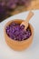 Wooden bowl with dried lavender on field background. Flower herbal tea drink. Aromatherapy, medicine ingredient. Calming beverage