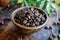 A wooden bowl filled with aromatic coffee beans rests on top of a sturdy wooden table, Luxurious Kopi Luwak coffee beans, AI