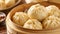 A wooden bowl filled with dumplings placed on top of a table