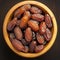 Wooden bowl filled with Medjool dates on table, top view