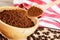 Wooden Bowl with fresh ground Roasted Coffee Grounds wooden background