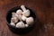 Wooden bowl of fresh raw champignon mushrooms on kitchen table. Autumn harvest, seasonal jrganic vegan food, healhty eating habits