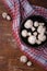 Wooden bowl of fresh raw champignon mushrooms on red kitchen towel. Autumn harvest, seasonal jrganic vegan food, healhty eating